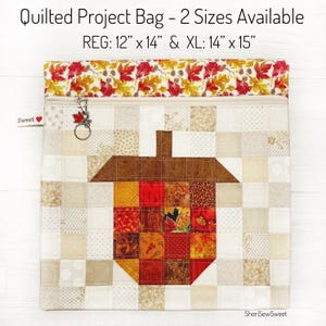 May include: Quilted project bag with an acorn design. The bag is available in two sizes: Regular at 12" x 14" and Extra Large at 14" x 15". The bag features a zipper closure and a fall-themed leaf pattern at the top. The bag is made of quilted fabric.