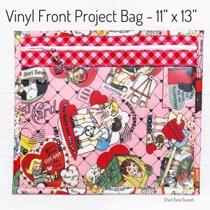May include: A pink vinyl project bag with a red and white checkered zipper closure. The bag is 11 inches by 13 inches and features a Valentine's Day themed print with hearts, children, and the text "You're just cut out for me".