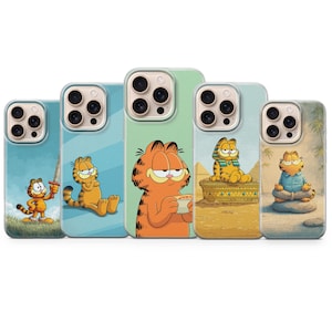 Puede incluir: Cinco fundas para teléfono con ilustraciones de Garfield. Cada funda presenta un diseño diferente de Garfield en varias poses y entornos. Las fundas son en tonos de azul, verde y beige, con el personaje naranja de Garfield como punto focal.
