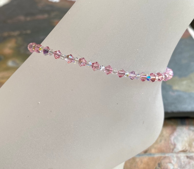 May include: A delicate anklet made with small pink and clear crystal beads.