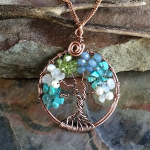 May include: Copper wire tree of life pendant necklace with turquoise, green, and blue gemstones.