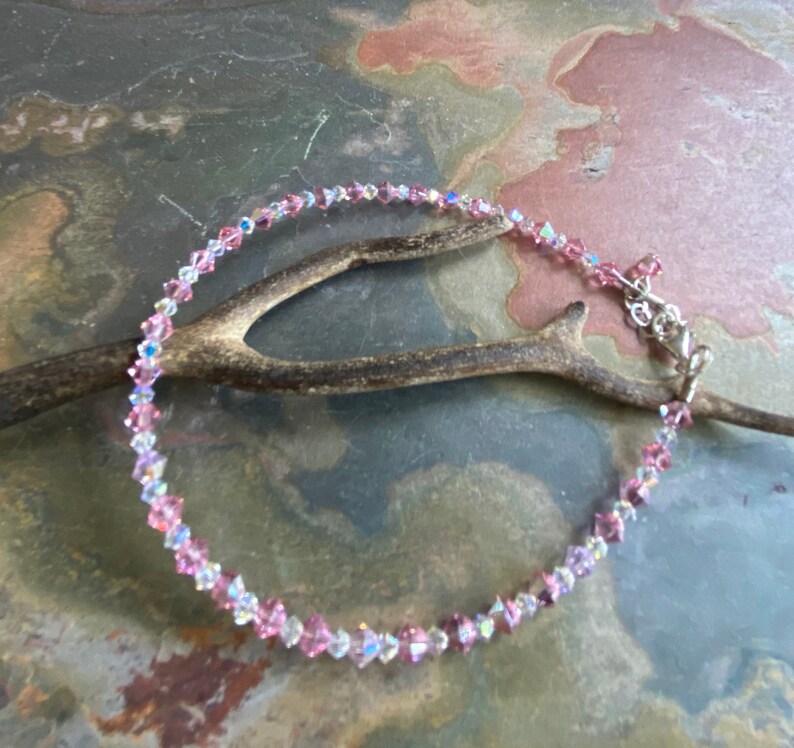 May include: A delicate anklet made with small pink and clear crystal beads. The anklet has a silver clasp.