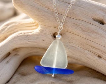 Peut inclure: Un collier avec un pendentif en forme de voilier, composé d'un morceau de verre dépoli blanc triangulaire pour la voile et d'un morceau de verre bleu cobalt incurvé pour la coque, le tout suspendu à une fine chaîne en argent.