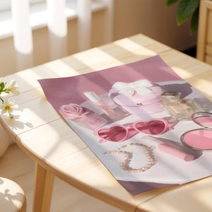 May include: A collection of pink beauty products and accessories, including heart-shaped sunglasses, a pearl necklace, a compact, perfume, and a rose-shaped container. The items are arranged on a pink surface, creating a feminine aesthetic.