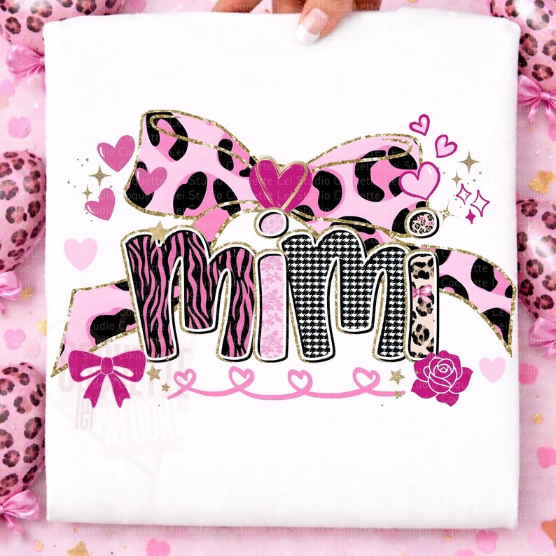 K&ouml;nnte beinhalten: Wei&szlig;es T-Shirt mit dem Wort "MIMI" in einem verspielten Design. Die Buchstaben sind mit Zebrastreifen, rosa Mustern und einem schwarz-wei&szlig;en Hahnentrittmuster verziert. Eine rosa Schleife und Herzen vervollst&auml;ndigen das Design.