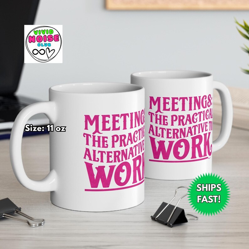 White ceramic mug with the phrase “Meetings: The Practical Alternative To Work” in bold pink text, styled on a black marble countertop in a luxury condo. Perfect gift for co-worker, colleague, boss - friend mum dad girlfriend boyfriend husband wife partner or special person in your life.