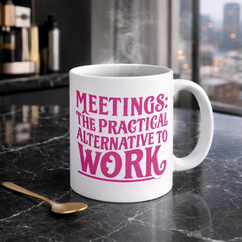 White ceramic mug with the phrase “Meetings: The Practical Alternative To Work” in bold pink text, styled on a black marble countertop in a luxury condo. Perfect gift for co-worker, colleague, boss - friend mum dad girlfriend boyfriend husband wife partner or special person in your life.