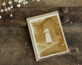 Vintage foto uit de jaren 1910, Edwardiaanse foto van een lachende vrouw, antieke zwart-wit sepia portretfoto