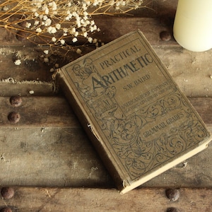 Libro clásico de la década de 1900, "Aritmética práctica, notas gramaticales" de S. W. Baird, publicado por American Book Company.