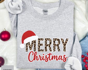 May include: A light gray sweatshirt with the words "MERRY Christmas" in a festive design. The word "MERRY" features a leopard print pattern, and a red Santa hat is placed above it. The word "Christmas" is in red script.