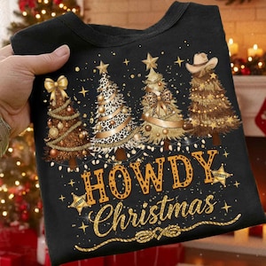 以下が含まれることがあります： 「Howdy Christmas」のデザインが施された黒いTシャツ。カウボーイハットとヒョウ柄のアクセント、金の星、保安官バッジが特徴の4本のクリスマスツリーのグラフィック。楽しいホリデーTシャツ。