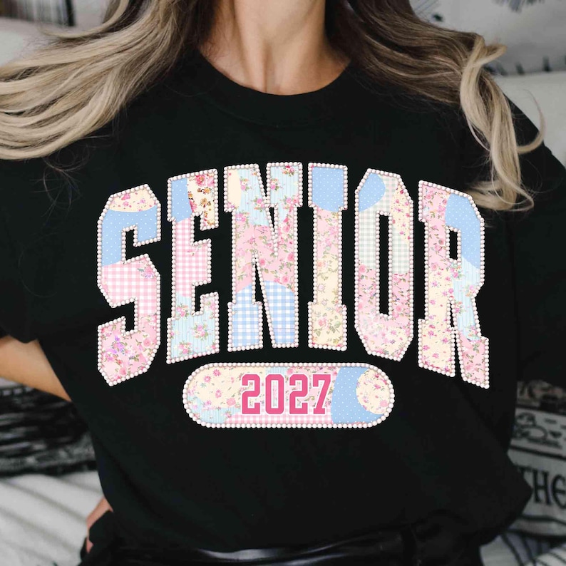 Peut inclure: T-shirt noir avec le mot "SENIOR" dans un motif patchwork floral et vichy. Le chiffre "2027" est en dessous dans un style similaire. V&ecirc;tement sur le th&egrave;me de la remise des dipl&ocirc;mes.