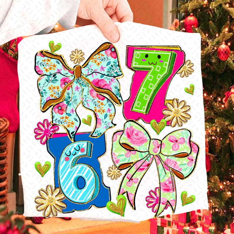 May include: A white fabric with colorful illustrations of the numbers 6 and 7, and two bows. The bows have floral patterns in pink, blue, and green. Gold glitter accents the bows, hearts, and flowers. The numbers are outlined in blue and pink.