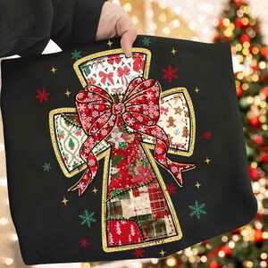 Puede incluir: Cojín navideño negro con un diseño de cruz y un gran lazo rojo. La cruz está compuesta por varios parches estampados, incluyendo lazos, copos de nieve, hombres de jengibre y cuadros escoceses. Ribete dorado y copos de nieve y estrellas dispersas completan el aspecto festivo.