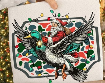 May include: A white rectangular pillow with a festive Christmas design. Santa Claus, in his red suit, rides a large duck with teal and black wings. The duck carries a lantern. The background features a colorful pattern and string lights.