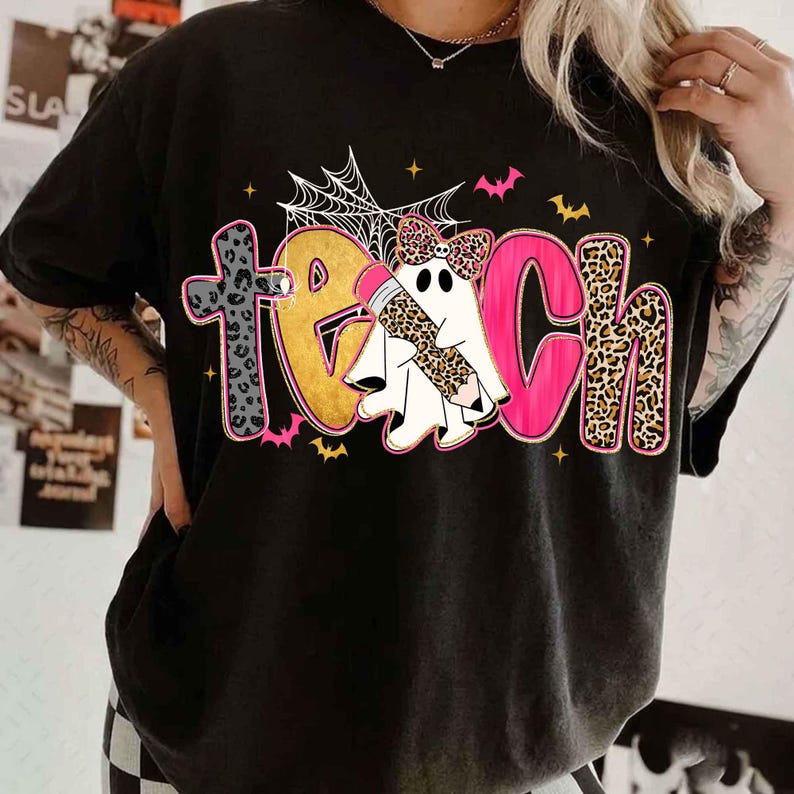Peut inclure: Un t-shirt noir avec le mot TEACH &eacute;crit en grandes lettres color&eacute;es. Le T est en imprim&eacute; l&eacute;opard gris, le E est dor&eacute;, le A est un fant&ocirc;me blanc avec un n&oelig;ud et un crayon l&eacute;opard, le C est rose et le H est en imprim&eacute; l&eacute;opard. Avec toiles d'araign&eacute;e et chauves-souris.
