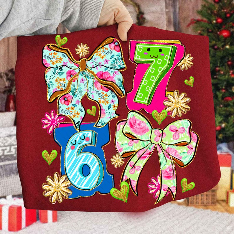 May include: A red fabric item featuring the numbers 6 and 7, along with two floral bows and decorative hearts and flowers. The bows have floral patterns in pink, blue, and green. The numbers are outlined in blue and pink.