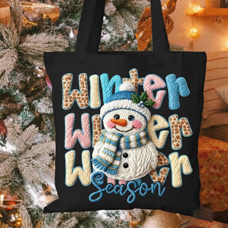 May include: Black tote bag featuring a snowman design with the words "Winter Winter Season". The snowman has a blue hat, scarf, and a carrot nose. The text is in various colors and patterns.
