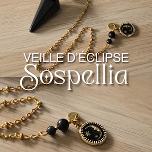 May include: A gold-coloured chain pendulum featuring a black, faceted crystal point and black beads. The chain leads to a circular charm with a black background and a crescent moon and star design. The text "VEILLE D'ÉCLIPSE Sospellia" is displayed.
