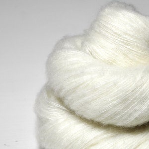 Puede incluir: Un ovillo de hilo blanco suave, perfecto para tejer o hacer ganchillo.