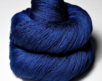 May include: A skein of deep blue yarn, tightly wound and textured. The yarn appears soft and is suitable for knitting or crocheting projects. The color is a rich, saturated blue, with subtle variations in tone.