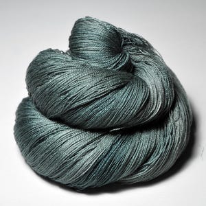 Peut inclure: Une pelote de fil de couleur sarcelle, soigneusement enroulée et présentée sur un fond blanc. Le fil présente un léger éclat, avec des variations de couleur allant du sarcelle clair aux nuances plus foncées, créant un aspect texturé. Idéal pour les projets de tricot ou de crochet.