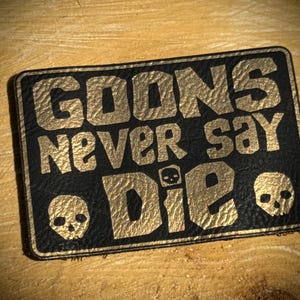 Könnte beinhalten: Set aus drei Keramikbechern mit gesprenkelter, matter Oberfläche. Die Becher sind in Creme-, Hellgrau- und Dunkelgrautönen gehalten. Jede Tasse hat ein schlichtes, minimalistisches Design.