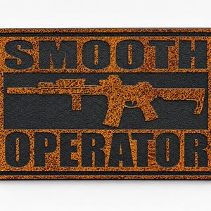 May include: A rectangular patch with a textured orange and black finish. The word SMOOTH is printed in black at the top, and OPERATOR is printed in black at the bottom. Between the words is a silhouette of a rifle in a textured orange finish.