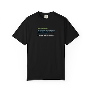 May include: Black t-shirt with the text "WHAT IS RECURSION?" in green and blue. The text explains recursion as a process where a function calls itself to generate a solution. The shirt is a casual wear item.