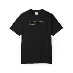 May include: Black t-shirt with green text that reads "GO ON DO NOT, THERE IS NO TRY IN PYTHON". Below the text is a code snippet. The shirt is a basic crew neck style.