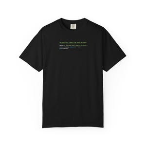 May include: Black t-shirt with green and blue text. The text reads "THE GEEK SHALL INHERIT THE EARTH IN PYTHON" followed by lines of code. The shirt has short sleeves and a crew neck.