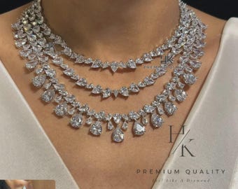 May include: A three-strand diamond necklace with a matching pair of earrings. The necklace features a graduated design with pear-shaped and round-cut diamonds. The earrings have a similar cascading design. The jewelry is set against a white background.
