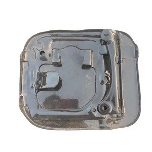 May include: A black car component with a shiny surface. It features raised areas and a hinged arm on the right. The shape is generally rectangular with rounded corners and a slight curve.