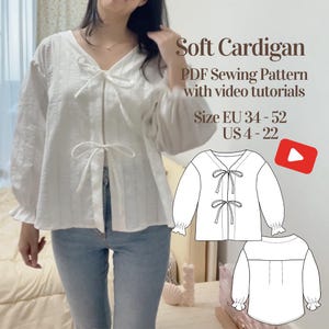 May include: A white soft cardigan with a V-neck and tie closures. The sleeves have a ruffled cuff. The image includes the text "Soft Cardigan PDF Sewing Pattern with video tutorials" and size information: US 4-22.