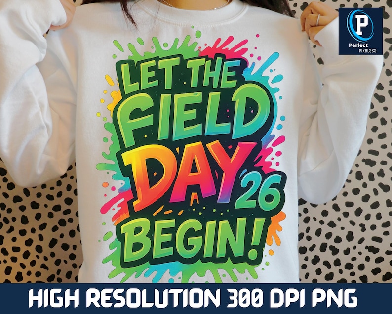 May include: White sweatshirt with a colorful graphic that reads "LET THE FIELD DAY 26 BEGIN!" The design features vibrant green, yellow, orange, and pink text with a splash effect. The sweatshirt is a crew neck style.