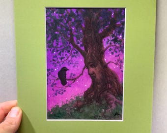 May include: A framed art print featuring a whimsical illustration of a tree with a face, set against a purple and pink starry sky. A black crow perches on a branch. The artwork is matted in white and framed in a light green.