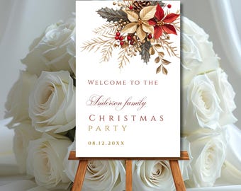 May include: A wooden easel displays a Christmas party welcome sign. The sign features floral arrangements with red poinsettias, gold accents, and the text "Welcome to the Anderson family Christmas Party" with a date. The background includes white roses.