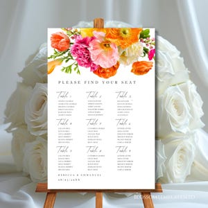 May include: A white seating chart with floral accents, featuring a colorful arrangement of orange, pink, and yellow flowers. The chart displays guest names organized by table number, with the text "PLEASE FIND YOUR SEAT".