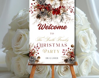 May include: A Christmas party welcome sign on a wooden easel. The sign has a white background with burgundy and gold text that reads "Welcome to The Smith Family Christmas Party." The sign is decorated with floral arrangements.