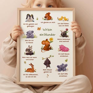 May include: A framed print featuring colorful illustrations of various animals and the German text "Ich bin ein Wunder" (I am a wonder). The print includes phrases like "I am loved" and "I believe in myself", with each phrase accompanied by a corresponding animal illustration.