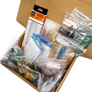May include: A cardboard box filled with various electronic components, including breadboards, resistors, and integrated circuits. The components are packaged in clear plastic bags and a box labeled "Solderless Breadboard MB-102". The box is open, revealing the contents.