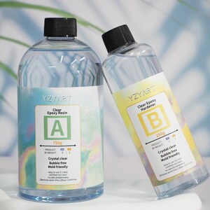 May include: Two clear bottles of YZYART epoxy resin and hardener. The resin bottle is labeled "A" and contains 750g. The hardener bottle is labeled "B" and contains 250g. Both bottles are crystal clear, bubble-free, and mold-friendly.