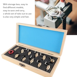 May include: A wooden box with a blue interior houses watch repair tools. The box contains various small, gold-colored tools and a red ring. The text on the image says, "With storage box, easy to find different models, easy to save and carry..."
