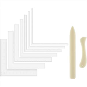 May include: A collection of clear plastic L-shaped rulers and straight rulers, with measurements in inches. Also included are two bone folders, one pointed and one curved, for paper crafting and bookbinding.