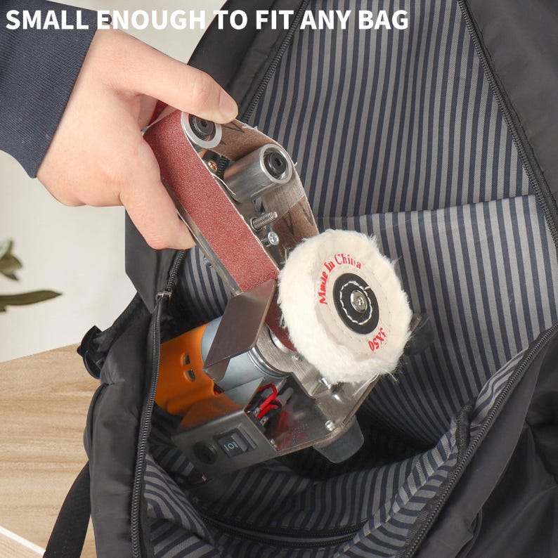 A hand is holding a small sanding machine with a white pad, which is being used to smooth a surface.