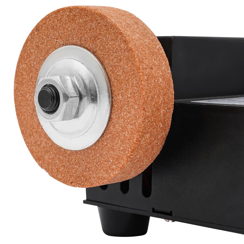 a close-up view of a grinding wheel with a metal nut attached to it, which is mounted on a black base.