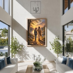 May include: A framed artwork depicts two figures walking along a path towards a sunset over a lake. The figures are bathed in warm light, with a detailed landscape of trees and water. The artwork is displayed in a modern living room setting.