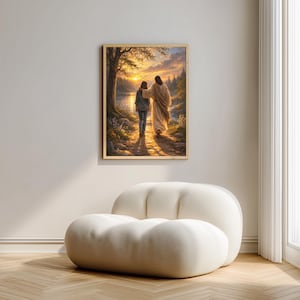 May include: A framed artwork depicts two figures walking on a path towards a sunset. The figures are illuminated by the golden light, with a lake and trees in the background. The artwork is displayed on a white wall above a white, rounded chair.