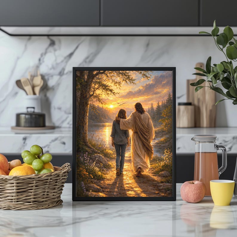 May include: Framed artwork depicting a person walking with another figure along a path at sunset. The painting features warm colors, a river, and trees. The artwork is displayed on a white marble countertop.