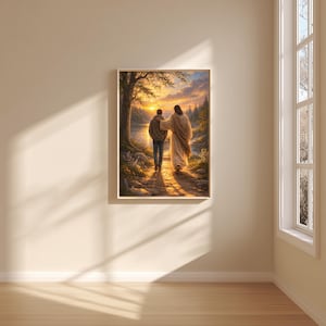 May include: A framed print depicts two figures walking on a path beside a river at sunset. One figure, in a robe, has an arm around the other, who wears a jacket and jeans. The scene is bathed in warm light, with trees and a bright sky.